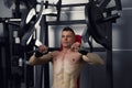 Bodybuilder workout on trainer in gym, perfect muscular male body Royalty Free Stock Photo