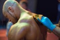 Bodybuilding competition backstage: contestant being oiled and fake tan applied to skin