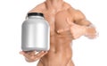 Bodybuilding and Sports theme: handsome strong bodybuilder holding a plastic jar with a dry protein and showing gesture isolated o Royalty Free Stock Photo