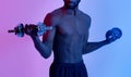 Bodybuilding and strength workout. Unrecognizable black guy with bare torso training with dumbbells in neon light