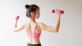 Bodybuilding. Strong fit woman exercising with dumbbells. Muscular Asian girl in pink sexy sportswear lifting weights Royalty Free Stock Photo