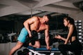 Bodybuiler couple trainig biceps. Personal trainer helping woman working with heavy dumbbells in gym. Sportsman concept Royalty Free Stock Photo