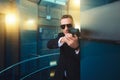 Bodyguard in suit and sunglasses with gun in hands Royalty Free Stock Photo