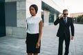 Bodyguard in sunglasses and black business woman