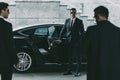 bodyguard in sunglasses opening car door