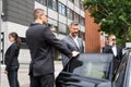 Bodyguards Protecting Businessman Opening Car Door Royalty Free Stock Photo