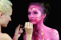 Bodypaint master in work, paints a model for a photo shoot Royalty Free Stock Photo