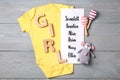 Bodysuit, list of baby names and toys on grey wooden background, flat lay Royalty Free Stock Photo