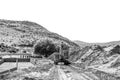 Backhoe loader clearing sand at Boegoeberg Dam. Monochrome