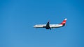 Boeing 737-900ER descends for landing at Adler airport runway against blue spring sky. Boeing 737-900ER VP-BZV