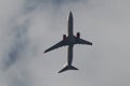 Boeing 737-900ER of Thai Lion Air flying in the cloudy sky