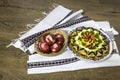 Traditional Romanian boeuf (beef) salad decorated and red Easter eggs with a traditional towel on a wooden table Royalty Free Stock Photo