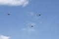 Three military black hawk helicopters with blue sky at background