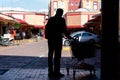 Silhouette of a Lonely man carrying a supermarket car full of groceries into Small Mall during obligatory quarantine