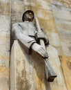 Closed up to an old stone statue of a Soldier holding a rifle guarding a military mausoleum in central cemetary