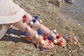 Bohemian greek sandals with colorful pom pom advertisement on the beach Royalty Free Stock Photo