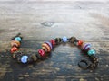 Women handmade bracelet made from bright beads on shabby wooden table. Bohemian handmade jewelry making craft concept Royalty Free Stock Photo