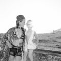 Mother and daughter outdoors in summer evening sitting on fence Royalty Free Stock Photo