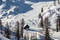 Bohinj, Slovenia - Winter view of the snowy mountain Vogel with skiers on ski slopes and wooden hut in the Alps at Triglav