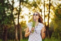 Boho Girl with bunch wildflowers and sunglasses in forest. Royalty Free Stock Photo