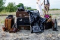 Boho wedding couple standing near vintage suitcases, near old retro cameras, camera cases and old lamp