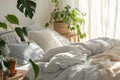 Boho style bedroom interior design. Cozy and elegant bright bedroom with big bed, nice white and beige bedclothes, green Royalty Free Stock Photo