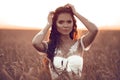 Boho style portrait of bohemian girl with white art posing over wheat field at sunset. Outdoors photo. Tranquility concept Royalty Free Stock Photo