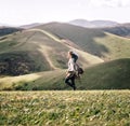 Woman walking in the mountains in windy weather.