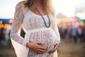 bohochic pregnant woman in a crochet top at a music festival