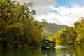 Bohol Loboc river cruise on Philippines. Palms, cloudy sky, hills Royalty Free Stock Photo