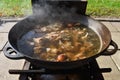 Boil the broth with meat and vegetables in a cauldron. Cooking shurpa soup over an open fire. Royalty Free Stock Photo