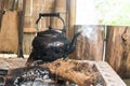 Boil water in the old aluminum kettle on burning firewood Royalty Free Stock Photo