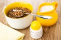 Boiled buckwheat, spoon in bowl, jug of milk, napkin, salt shaker on table