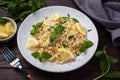 Boiled bulgur with fresh lemon and mint on a plate. A traditional oriental dish called Tabouleh. dark wooden background