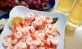 Boiled Caridean Shrimp served with sliced fresh lemon. Two glasses with cold white wine. Red grapes for dessert Royalty Free Stock Photo