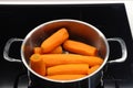 Boiled carrots in a metal pan, diet food, cooking on an electric stove