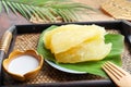 Boiled cassava or tapioca in syrup served with coconut milk - Thai dessert served in bamboo tray of the wood table