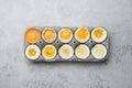 Boiled chicken eggs of different readiness stages in carton on light grey table, top view Royalty Free Stock Photo