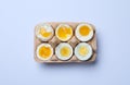 Boiled chicken eggs of different readiness stages in carton on white background, top view Royalty Free Stock Photo