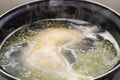 Boiled chicken in a pot broth close-up with blurred background and front Royalty Free Stock Photo