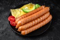 Boiled chicken sausages with scrambled eggs, avocado and tomatoes. Nutritious, tasty, healthy food.