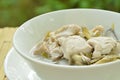 Boiled chicken with slice banana blossom in coconut milk soup on bowl