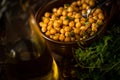 Boiled chickpeas in bowl with spoon, carafe with olive oil, herb in dark Royalty Free Stock Photo