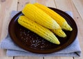 Boiled cobs of sweet corn on a clay plate. Royalty Free Stock Photo