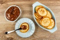 Boiled condensed milk in bowl, spoon with condensed milk on pancake in saucer, pancakes in plate on table. Top view Royalty Free Stock Photo