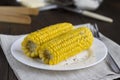 Boiled corn on the white plate on the table.