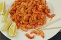 boiled craw fish meat on the plate with lemon slices, Japanese sticks, salad and straw mat closeup photo