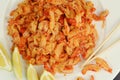 boiled craw fish meat on the plate with lemon slices, Japanese sticks, salad and straw mat closeup photo