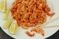 boiled craw fish meat on the plate with lemon slices, Japanese sticks, salad and straw mat closeup photo