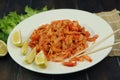 boiled craw fish meat on the plate with lemon slices, Japanese sticks, salad and straw mat closeup photo